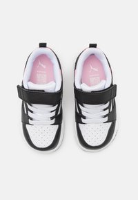 Chaussures de sport noire et blanche avec une tige en cuir et en mesh. Elles sont dotées d'une sangle Velcro ajustable, d'un bout perforé et d'un intérieur rose.