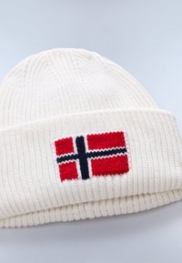 Gorro de punto blanco con diseño de bandera noruega roja y acentos azules y blancos en el dobladillo frontal. Textura de canalé vertical.