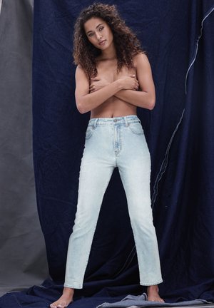 Šviesiai mėlynos džinsinės kelnės su aukštu liemeniu, liesu siluetu ir penkių kišenių dizainu. Lygus tekstūra, minimalūs siūlai palei siūles.