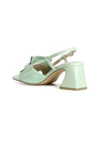 Minttivihreät mokka slingback-kengät, joissa on kolmiomainen paksu korko ja koristeellinen nauha edessä. Avoin kärki.