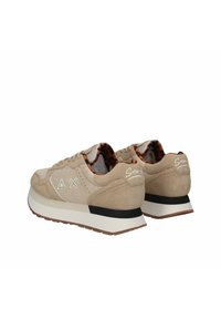 Sneaker scamosciate beige con una robusta suola bianca, dettagli geometrici ai lati e una fodera in stampa leopardata visibile all'interno della scarpa.