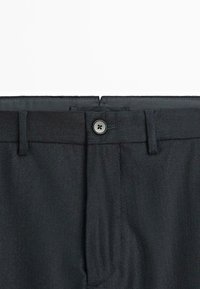 Zwarte broek met een rechte pasvorm, voorzien van een enkele knoopsluiting, riemlussen en een subtiele textuur.