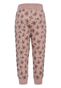 Roze joggerbroeken met een bloemenpatroon, met paarse bloemen en groene bladeren. Geribde tailleband en boorden, ontspannen pasvorm, zachte stof.