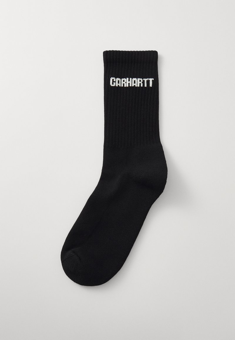 Calzino in cotone nero con texture a costine e tallone rinforzato, che presenta il nome del marchio ricamato in bianco "CARHARTT" sul risvolto.