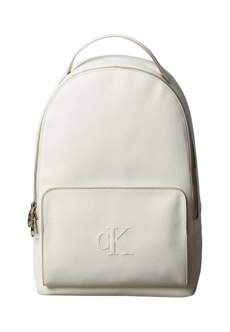 Bílý látkový batoh s zaobleným vrškem, přední kapsou na zip, vystouplým logem a texturovaným povrchem. Obsahuje rukojeť pro přenášení.