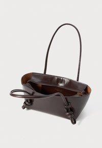 Bolso de piel marrón oscuro con dos asas, detalles de nudos y una cremallera abierta que revela un interior beige, todo sobre un fondo blanco.