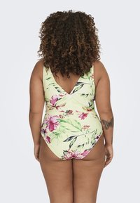 Kollase lillemustriga üheosaline ujumistrikoo, millel on erksad roosa ja roheline lillemuster. Omab V-taha disaini ja laia õlavarre rihma.