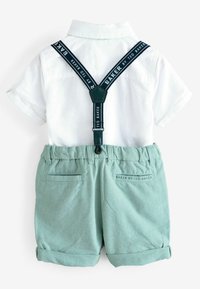 White short-sleeve shirt with a folded collar, paired with light green shorts featuring rolled cuffs and adjustable dark straps labeled "BAKER."
