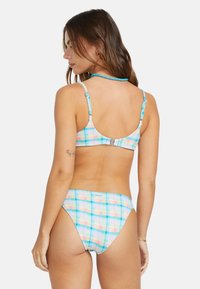 Bikini sæt med ternet design; pastelfarver i pink, blå og gul. Blødt stof, justerbare stropper og kroglukning bagpå.