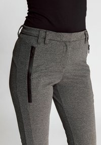 Gray patterned pants with a smooth texture, featuring a side zipper pocket and a slim fit design, made from stretch fabric.