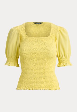 Κίτρινο τοπ με σμόκιν, τετράγωνο ντεκολτέ, φουσκωτά μανίκια έως τον αγκώνα και βολάν στα μανσέτα και το τελείωμα.