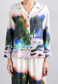 Silkeskjorta med knappar som har en färgglad, abstrakt landskapsdesign i nyanser av grönt, blått, rosa och svart. Långa ärmar och krage.