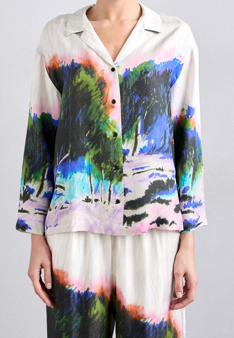 Silkeskjorta med knappar som har en färgglad, abstrakt landskapsdesign i nyanser av grönt, blått, rosa och svart. Långa ärmar och krage.