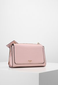 Różowa syntetyczna torba o wyraźnym kształcie, z złotymi akcentami i czarnym wykończeniem. Wyposażona w łańcuszkowy pasek i odczepianą metkę.