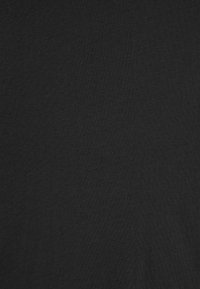 Tissu noir avec une finition douce et texturée, présentant une couleur uniforme et un motif minimal, adapté à divers vêtements.