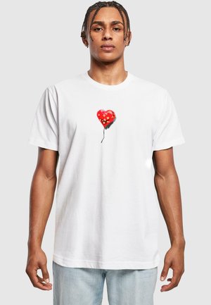White cotton t-shirt featuring a red heart-shaped balloon graphic with floral accents and a black string. Classic crew neck design.