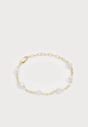 Arany lánc karkötő, amelyet szabálytalan fehér gyöngyök díszítenek, kengyelzárral, váltakozó szemekkel és sima, fénylő textúrákkal.
