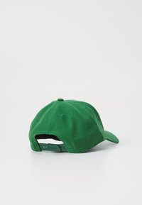 Grønn bomull baseballcap med buet skjerm, justerbar stropp bak og ventilasjonsøyelatter på toppen. Myk tekstur, enkelt design.