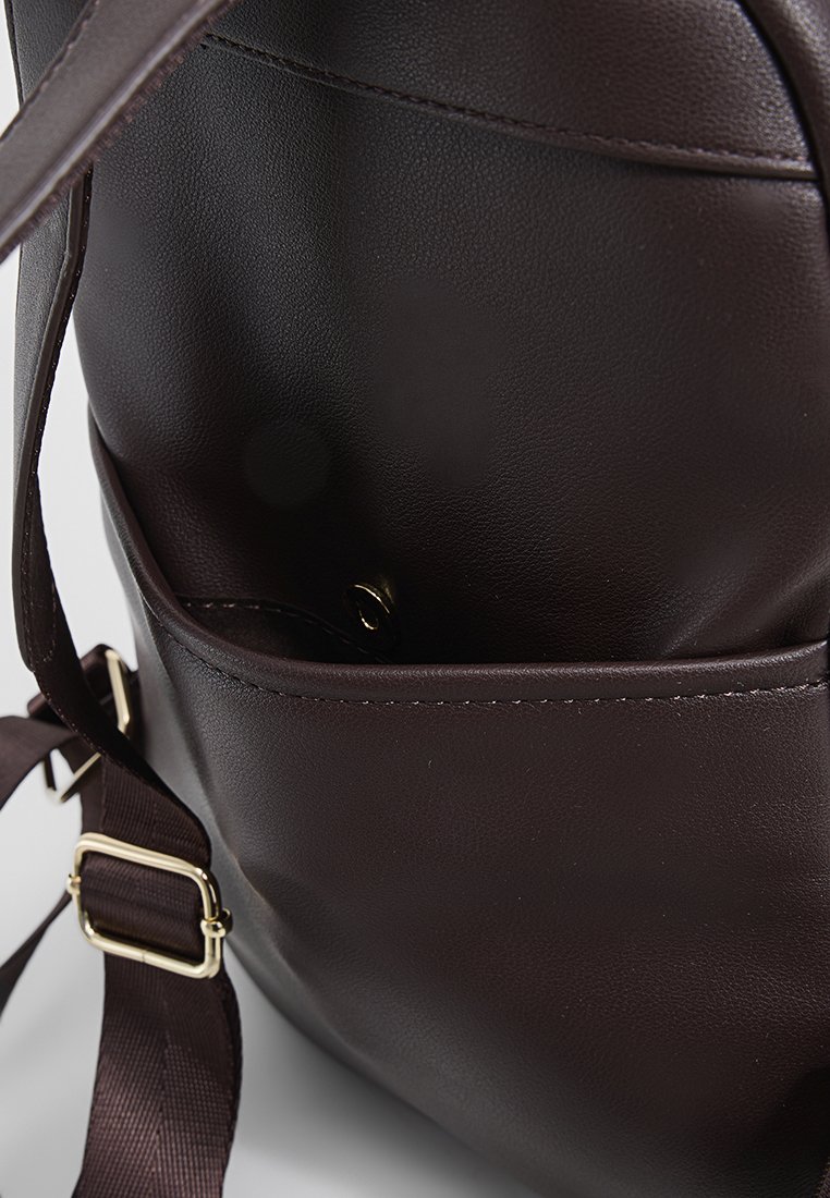 Braune Leder-Schultertasche mit glatter Textur, verstellbarem Riemen und einer Reißverschlusstasche innen für sicheren Stauraum.
