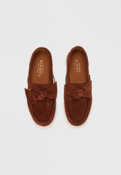 Ζεύγος καφέ σουέντ loafers με κόμπους φιόγκους στην κορυφή και δερμάτινες εσωτερικές σόλες με σφραγίδα «Alexandre Birman Κατασκευασμένο στην Ιταλία».