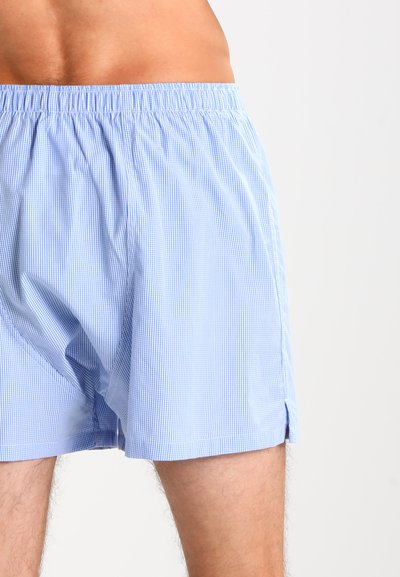 Svetlo modri karirasti bokserki z elastičnim pasom, ki imajo stranske razpoke za udobje in gladko bombažno teksturo.