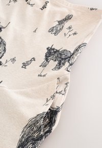 Tissu beige avec des impressions d’animaux style croquis noirs, comprenant des poulets, des canards et de petites fleurs dispersées sur la surface.