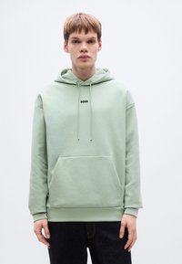 Φωτεινό πράσινο φούτερ με κουκούλα από μαλακό ύφασμα, με τσέπη καγκουρό, κορδόνια ρύθμισης και μαύρο λογότυπο "BOSS" στο κέντρο του στήθους.