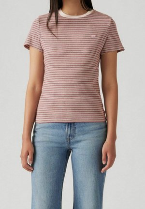 Rød- og hvidstribet T-shirt med korte ærmer, en cremefarvet rund halsudskæring og en lille mærketag på venstre bryst. Kombineret med lyseblå jeans.