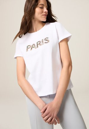T-shirt en coton blanc à manches courtes avec "PARIS" en lettres texturées multicolores. Coupe décontractée et décolleté arrondi. Design simple.