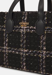 Czarna torebka z tweedu z wielokolorowym wzorem w kratę, złotym akcentem logo oraz czarnymi uchwytami z syntetycznej skóry. Posiada subtelne detale z efektem połysku.