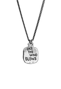 Silverhänge med en texturerad fyrkantig charm graverad med "SOM VINDEN BLÅSER," hängande från en länkad kedja.