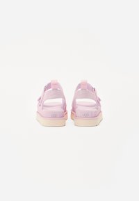 Rosa sandaler med åpen bak, som har et mykt tekstilovermateriale, justerbare stropper og gummisåler med strukturert grep. Logo synlig på hælen.