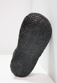 Zwarte rubberen schoenzool met een gestructureerd bladmotief. De hak is afgerond en de algehele vorm is licht gebogen.