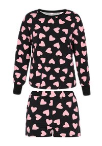 Svart pyjamasset i bomull, bestående av långärmad topp och shorts, prydd med rosa hjärtan. Elastisk midja på shorts.