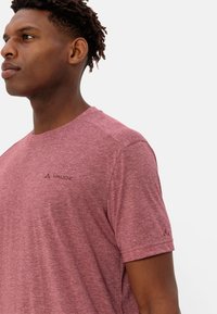 T-shirt a maniche corte rosso melangiato con scollatura rotonda, dotato di un logo discreto sul petto a sinistra e tessuto dal look testurizzato.