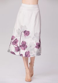 Une jupe blanche arrivant au genou avec un motif floral dans des tons de violet et de gris. Tissu lisse avec un ourlet évasé et une taille ajustée.