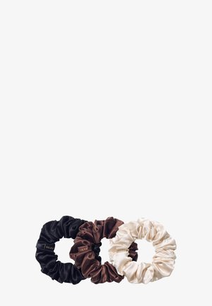 Drei Satin-Haargummis in Schwarz, Braun und Creme mit einer glatten Textur und einem gerafften Design sowie einem kleinen Markenetikett.