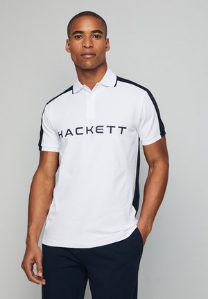 Weißes Polohemd mit marineblauen Schulterakzenten und großem "HACKETT"-Schriftzug über der Brust. Weiches Material und klassisches Kragen-Design.