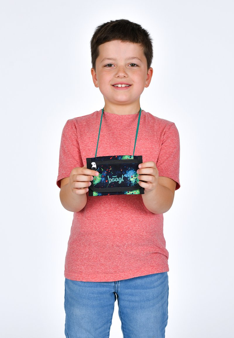 Sacca in canvas con base nera, motivo a macchie colorate e chiusura con zip, tenuta da un bambino in t-shirt rossa e jeans blu.