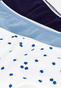 Tre paia di biancheria intima: blu navy, azzurro chiaro e bianco con pois blu e dettagli arancioni. Materiale in cotone morbido e bordo in pizzo sui lati.