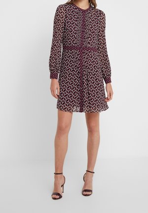 Robe en maroon transparent avec un motif géométrique en blanc et vert, manches longues, devant à boutons, taille froncée et ourlet à étages.