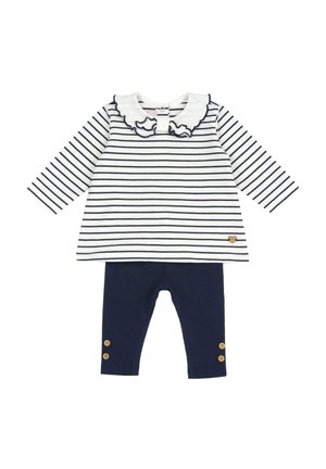 Pasiasty top z długim rękawem w biało-granatowe paski, z falbankowym kołnierzykiem; połączony z granatowymi legginsami z drewnianymi guzikami na kostkach.