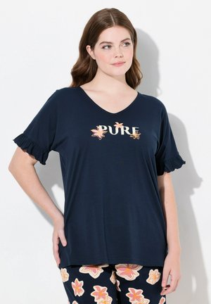 Navyblauwe V-hals T-shirt met gerimpelde mouwen, voorzien van de tekst "PURE" en roze bloemaccenten. Gecombineerd met gebloemde broek met een patroon.