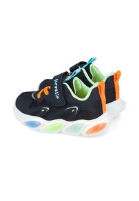 Zapatillas negras con parte superior de malla, acentos naranjas y azules, correa de velcro y suela multicolor con luces. Forro y acolchado verdes.