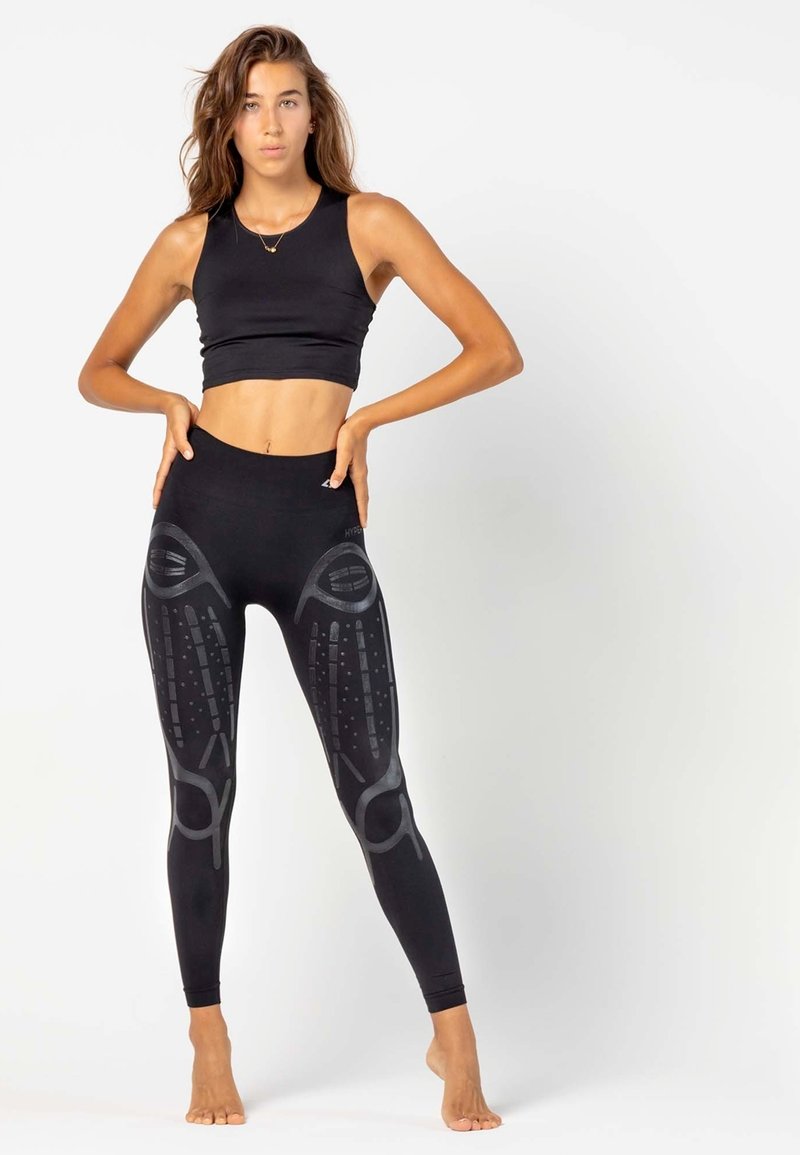 Zwarte sportcrop top en high-waisted legging met gestructureerde grafische patronen. Gladde stof, getailleerd ontwerp en naadloze constructie.
