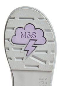 Suela de zapato blanca con agarre texturizado. Forma de nube central en púrpura con un rayo, grabada con el texto "M&S".