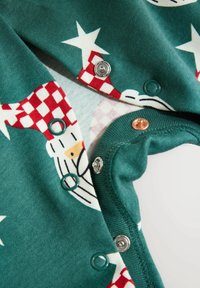 Zielona bawełniana bodówka z świątecznym wzorem w czerwono-białe akcenty, gwiazdki i napy w kolorze srebrnym i zielonym. Miękka faktura.