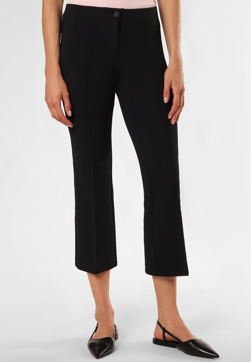 Zwarte cropped broeken met een gestructureerd oppervlak, aansluitende pasvorm en voornaaddetails, gecombineerd met zwarte slingback schoenen.