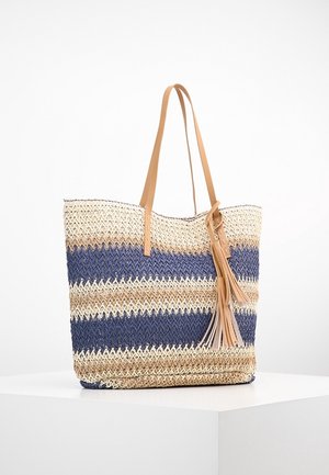 Sac cabas tissé avec des rayures horizontales bleues, beige et crème, poignées en cuir camel et détail pompon en cuir assorti.