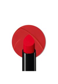 Rød leppestift med spiss tupp, i en svart tube. En sirkulær rød fargeprøve står bak, som viser produktfargen.